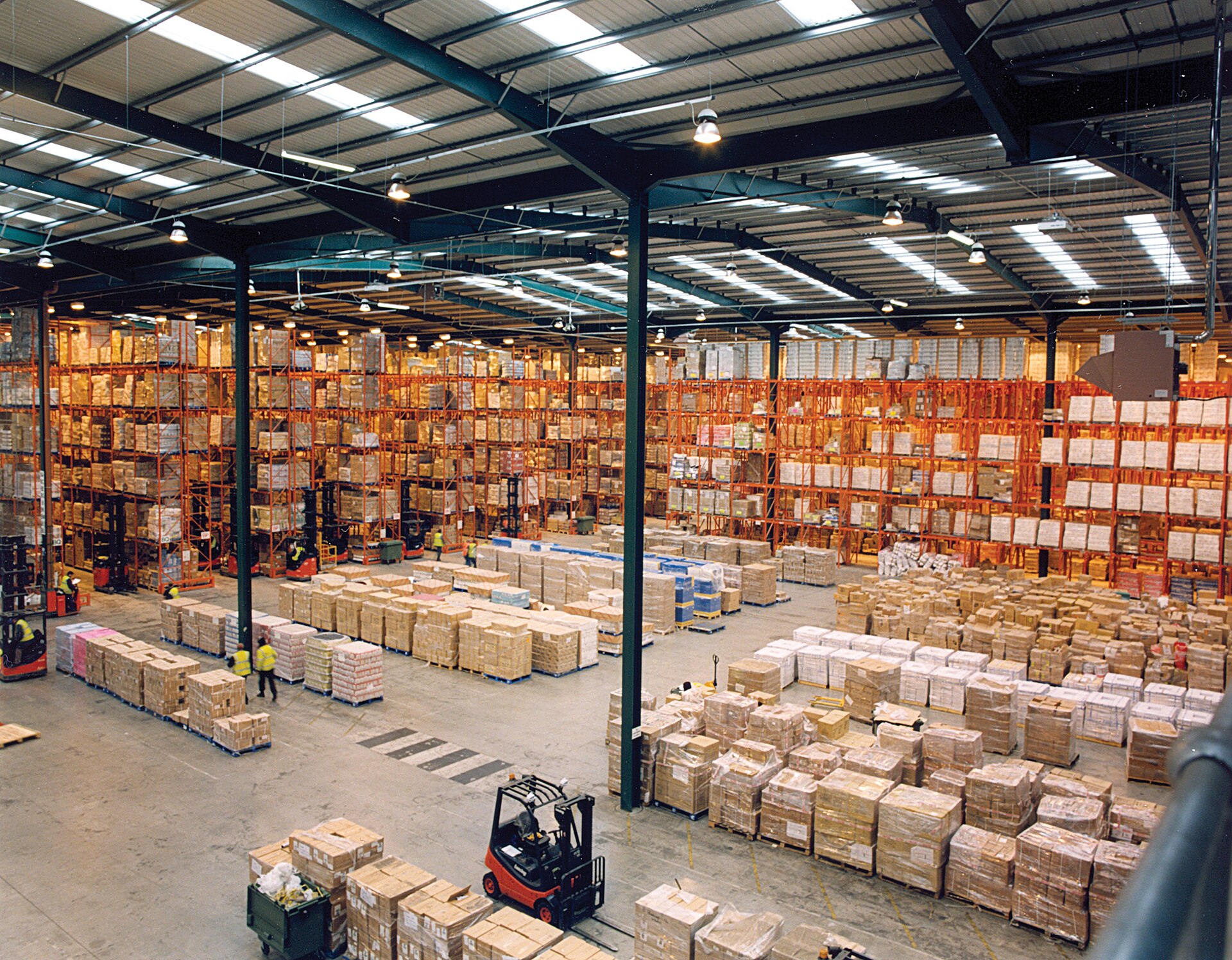 A large warehouse with tall pallet racks of boxed stock