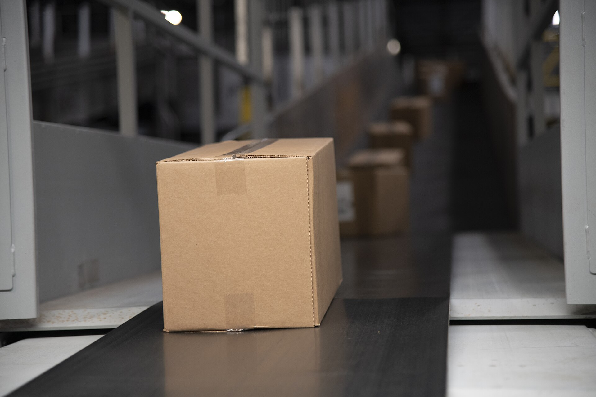 A single cardboard parcel on a conveyor belt in a sorting centre